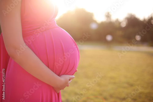 Wallpaper Mural Close up of cute pregnant belly in sunset outside in the park, o
