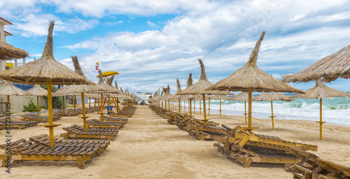 Romanian beach in a windy day, terrace with straw umbrellas photo