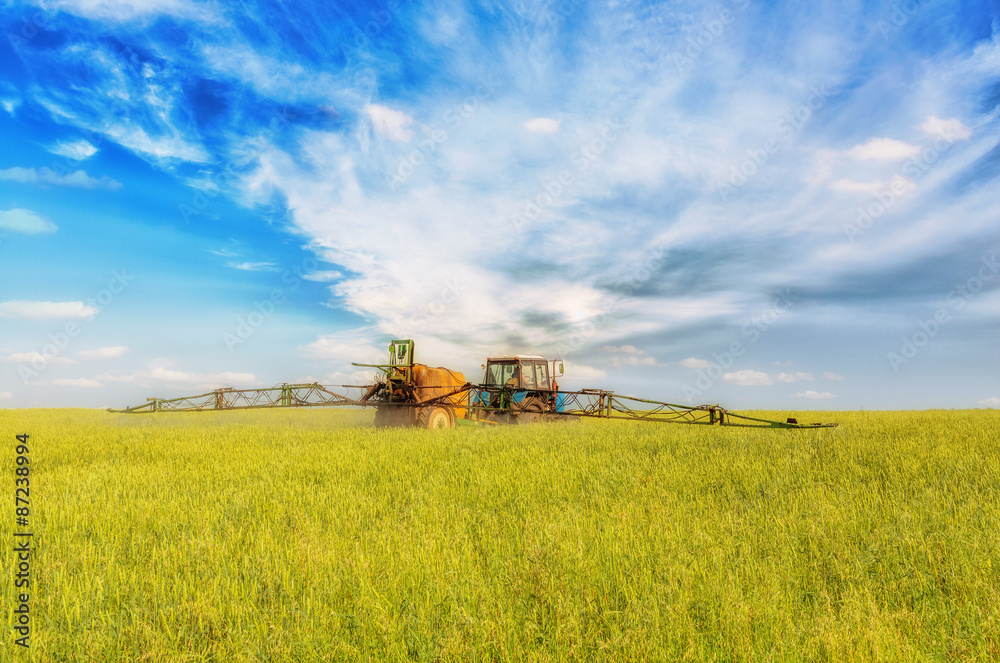 Farming tractor spraying green field Farming tractor spraying green field