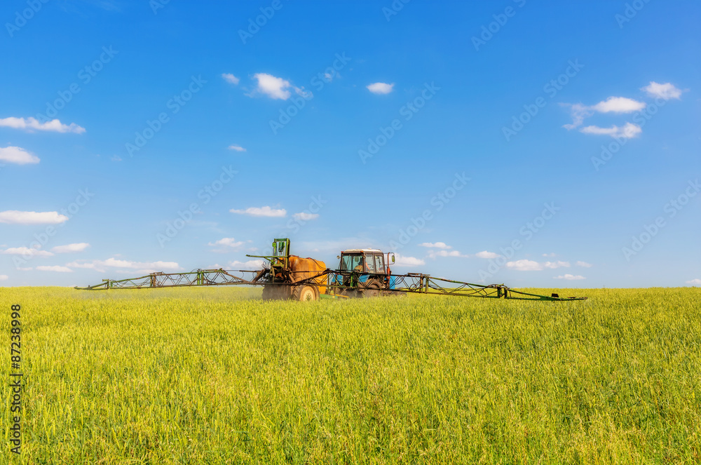 Farming tractor spraying green field Farming tractor spraying green field