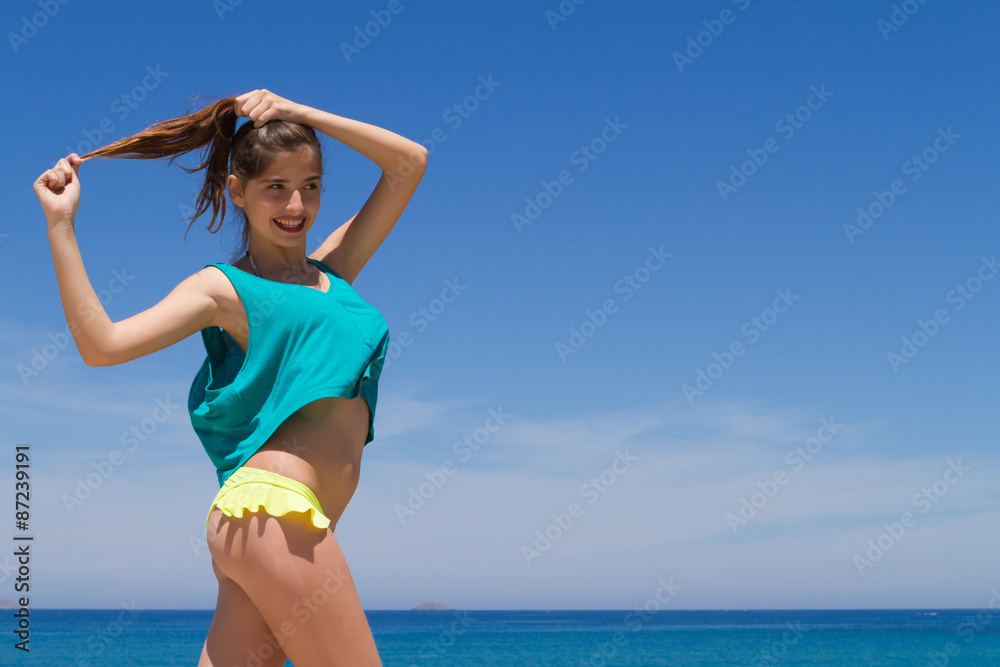 Brunette teen in bikini and beachwear enjoys the summer sun. - obrazy, fototapety, plakaty 