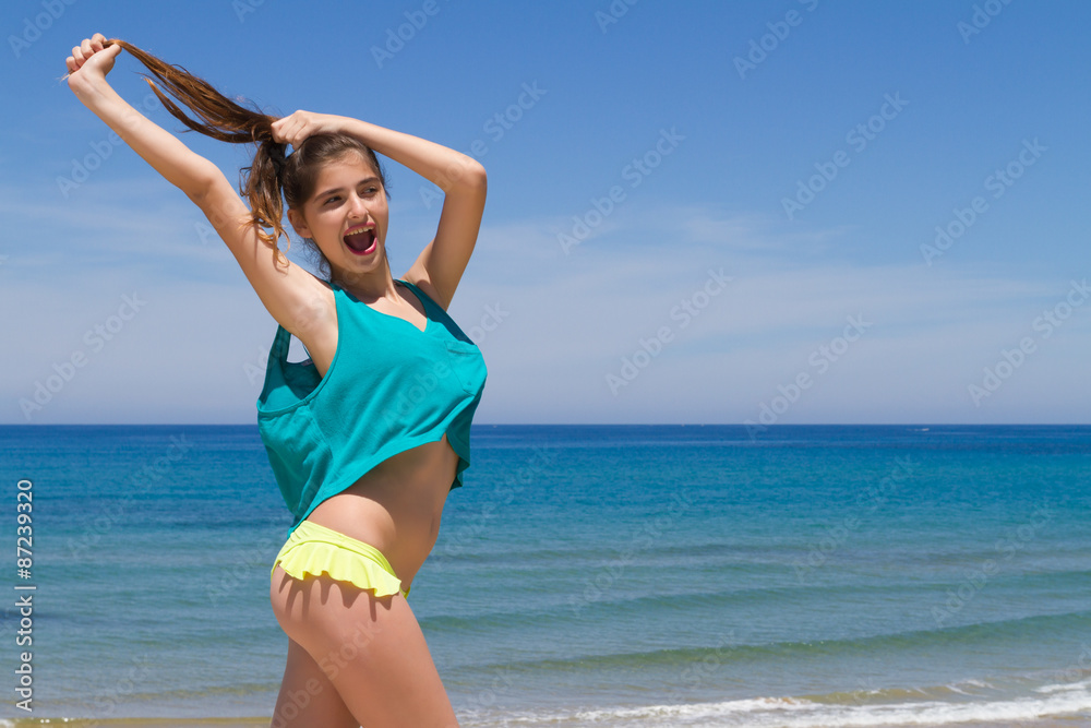 Brunette teen in bikini and beachwear enjoys the summer sun. Stock Photo
