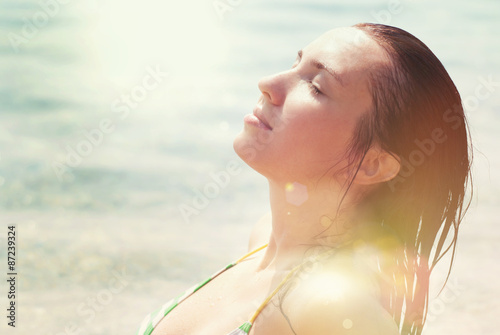 Beautiful Woman lying on the Beach in Summer Sunny Day. Sun beams. Bright Summer Sun Light, Summer Colors. Vacation