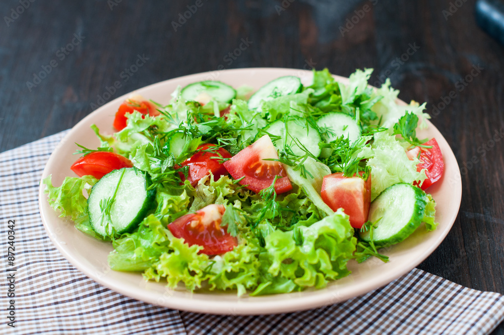 Tomato and cucumber salad with lettuce leafes Tomato and cucumber salad with lettuce leafes