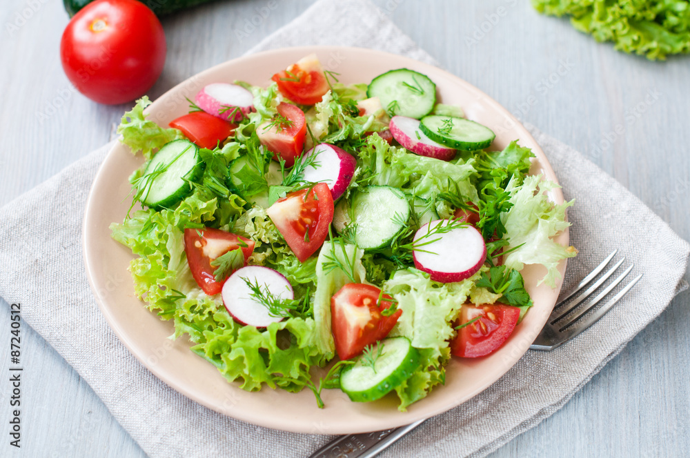 Tomato and cucumber salad with lettuce leafes