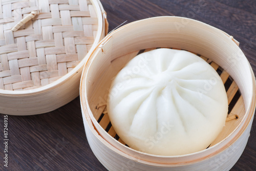 Fotografie Traditional chinese cuisines steamed bun in asian style bamboo basket