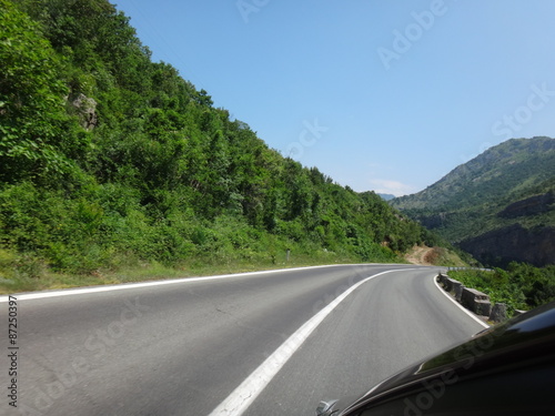 Автомобильная трасса в горах, уходящая вдаль в летний день