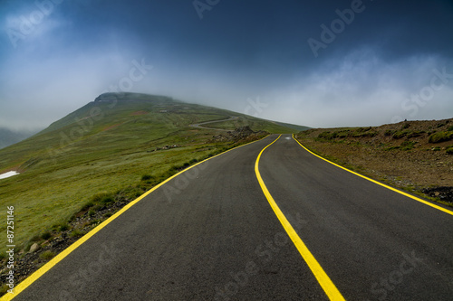 High altitude road into the mountains in foggy day