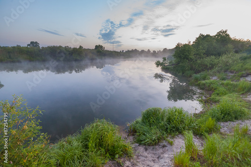 summer sunrise over the river with a fog