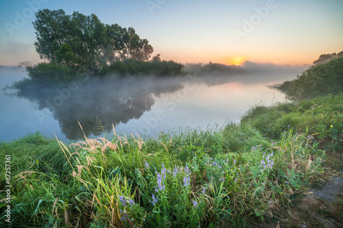 summer sunrise over the river with a fog