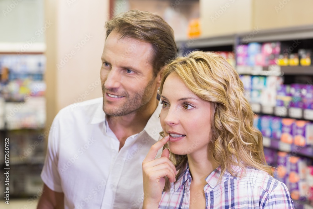 Smiling casual couple looking at shelf Smiling casual couple looking at shelf
