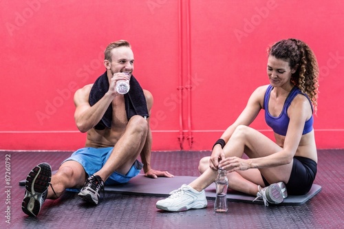 Sitting muscular couple talking together