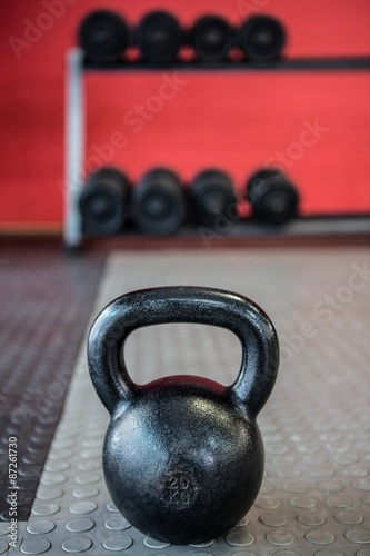 Close up view of kettlebell in front of dumbbells 