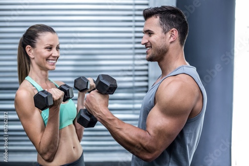 A muscular couple lifting dumbbells © WavebreakmediaMicro