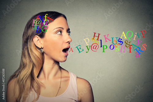 woman talking alphabet letters in her head coming out of open mouth photo