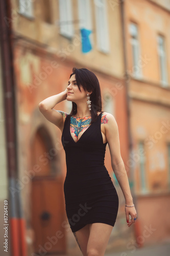 beautiful girl in black dress walking in the city