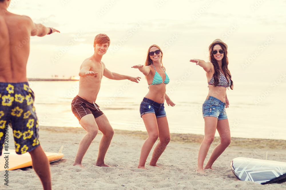 smiling friends in sunglasses with surfs on beach smiling friends in sunglasses with surfs on beach
