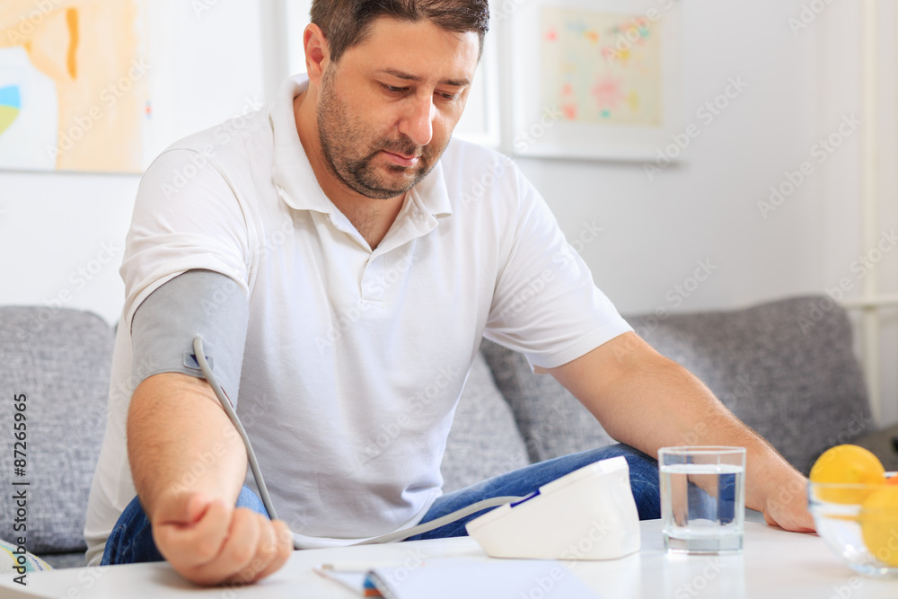 Man measuring his blood pressure waiting on the results