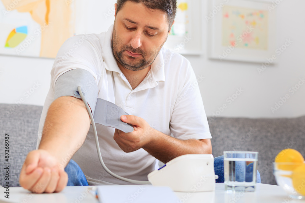 Man placing a blood measuring device onto his arm. Measuring blood pressure. Man placing a blood measuring device onto his arm. Measuring blood pressure.