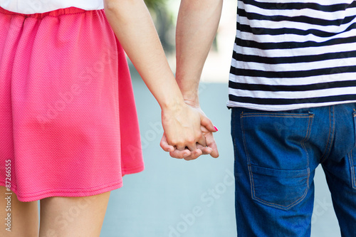 Young couple holding hands, rear view 