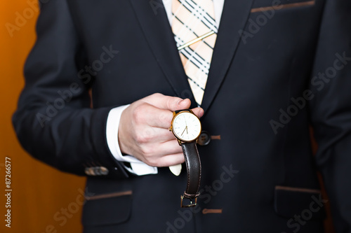 young business man looking at watch over white background
