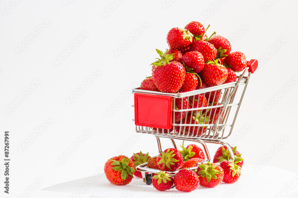 A lot of strawberries at miniature shopping cart