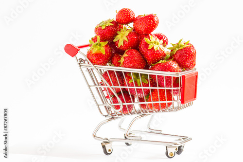 A lot of strawberries at miniature shopping cart