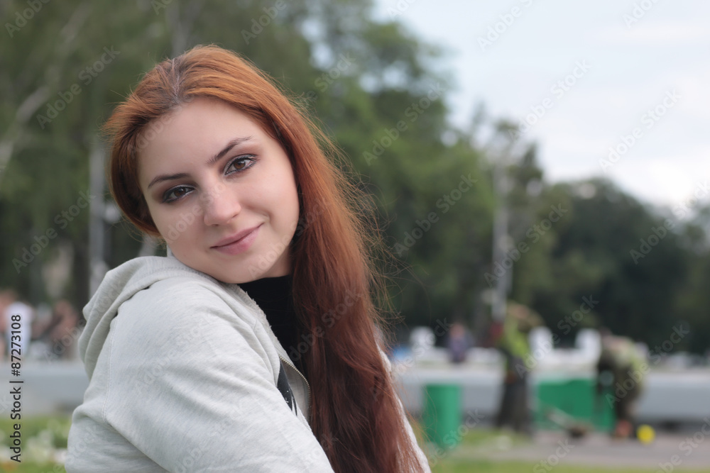 Portrait of red-haired girl in the park