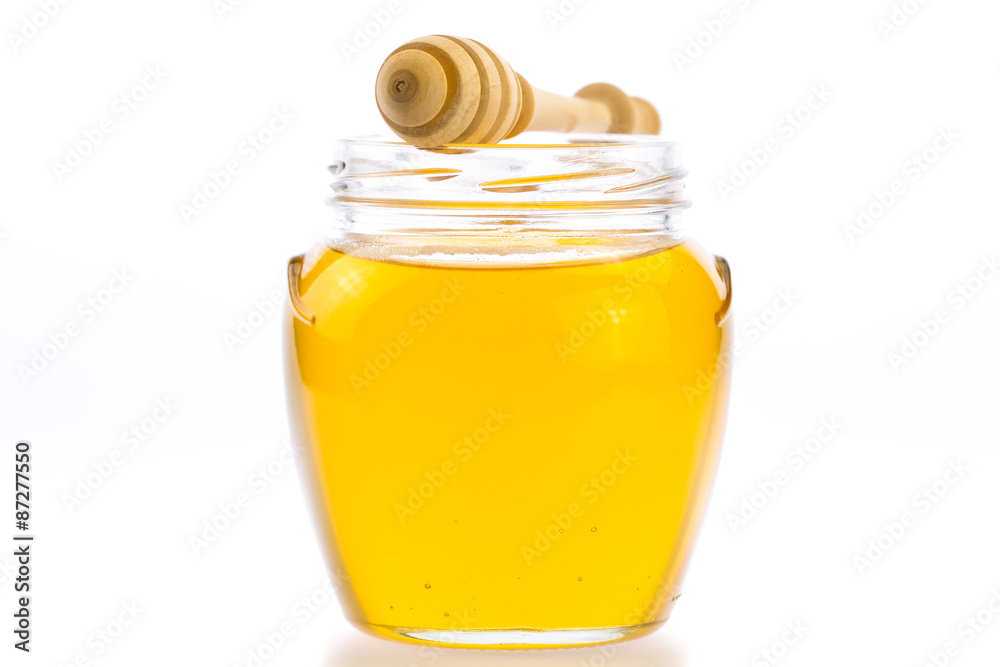glass jar of fresh honey with drizzler isolated on white background glass jar of fresh honey with drizzler isolated on white background