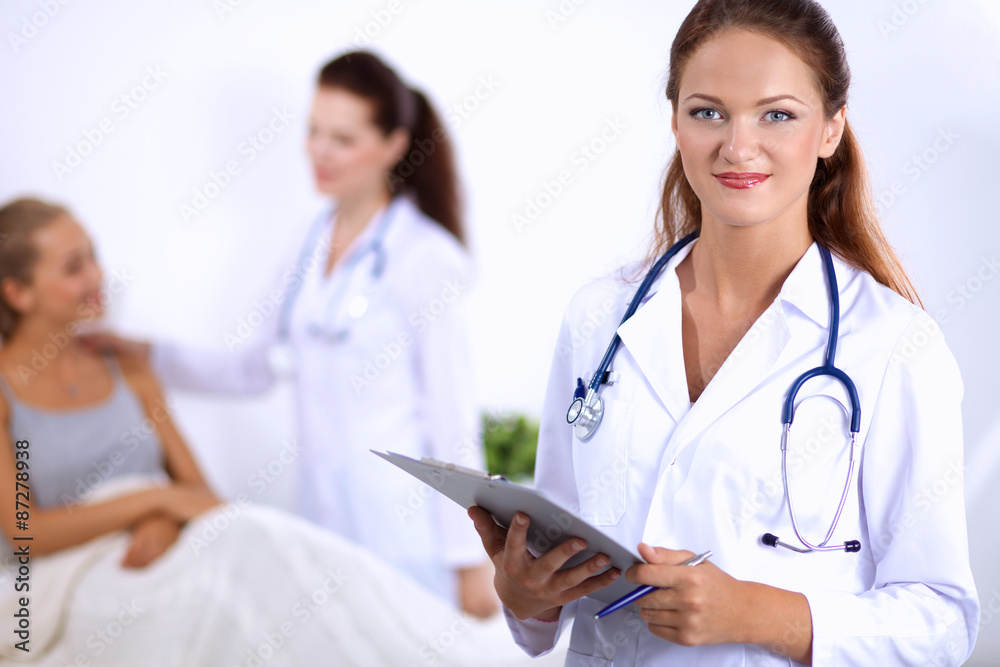 Smiling female doctor with a folder in uniform standing at Smiling female doctor with a folder in uniform standing at