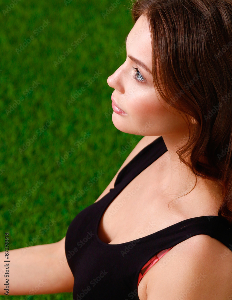 Woman sitting with crossed legs on the green grass Woman sitting with crossed legs on the green grass