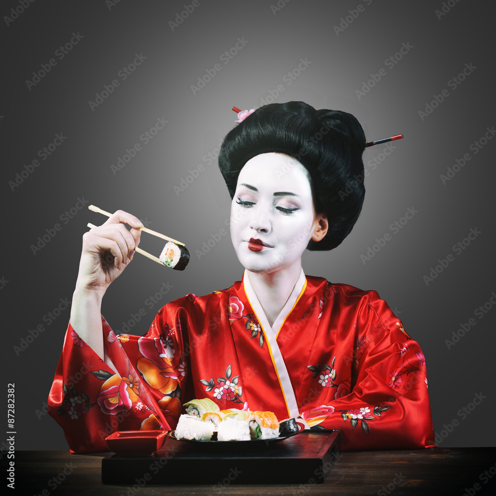 Woman in geisha makeup eating sushi Stock Photo | Adobe Stock