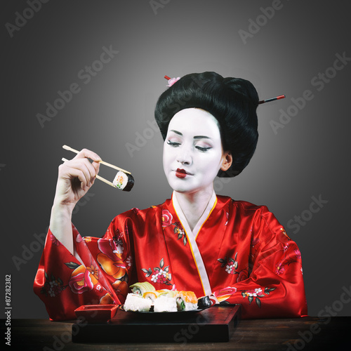 Fotografie, Tablou Woman in geisha makeup eating sushi