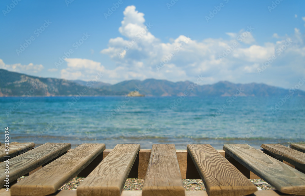 wooden planks at foreground with sea and mountains at background