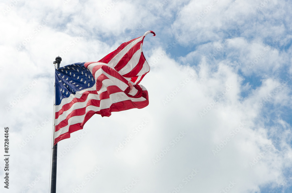 Naklejka premium Amerykańska flaga amerykańska macha na wietrze z pięknym niebieskim pochmurne niebo w tle