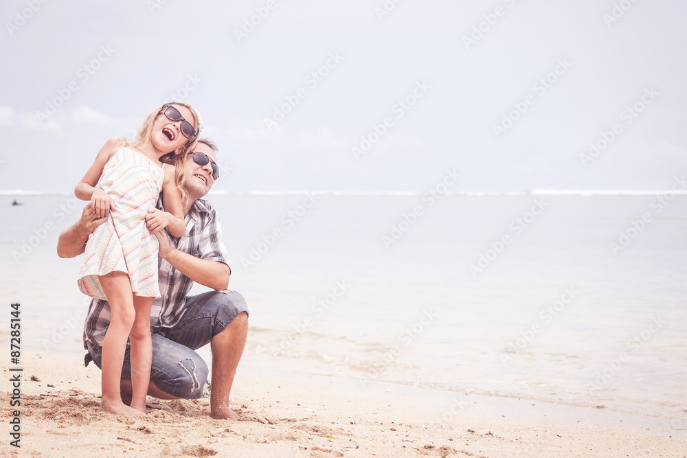 Father and daughter playing on the beach at the day time. Father and daughter playing on the beach at the day time.