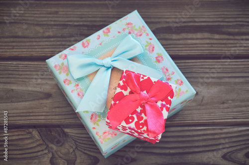 Two gift boxes on a wooden background in center. horizontal