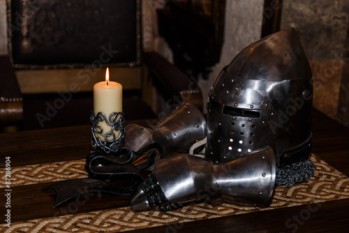 Photography knight's helmet with visor and gloves on the table