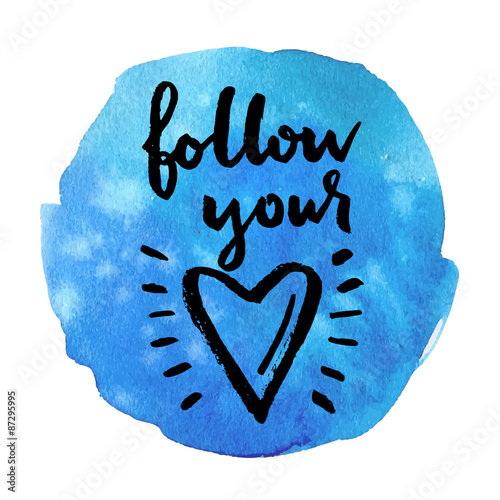 Follow your heart. Hand drawn calligraphic quote on a blue watercolor background.