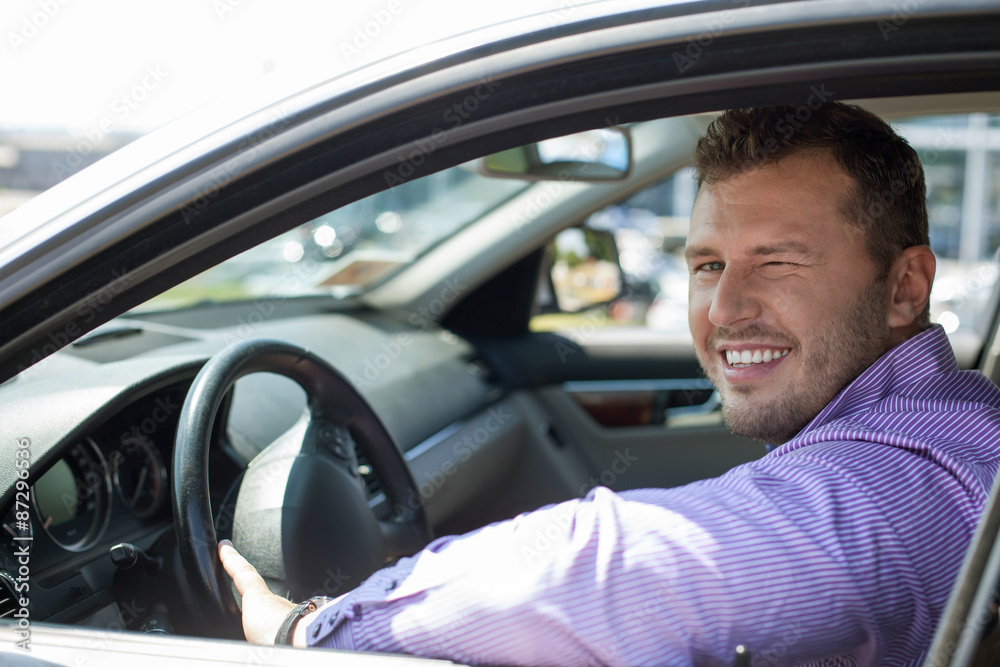 Handsome young man is driving his car