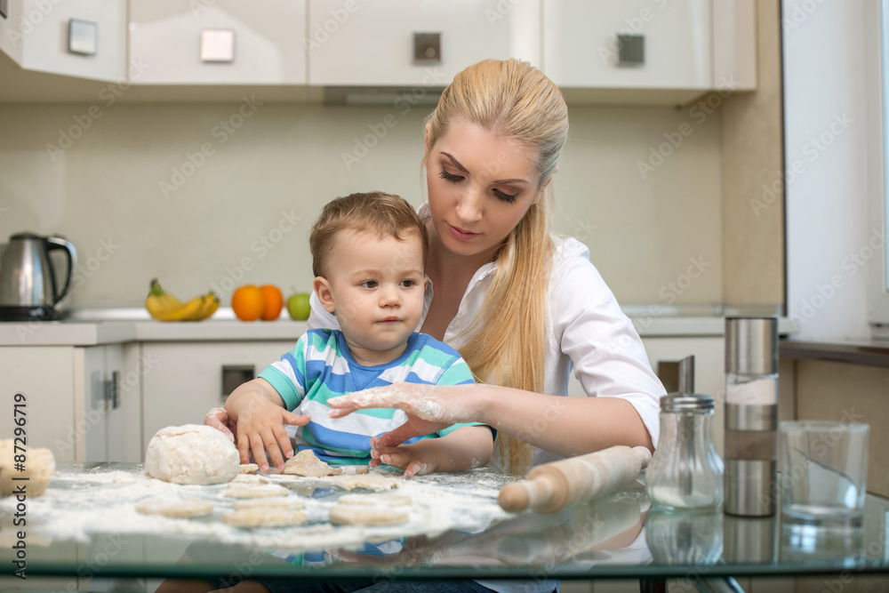 Young beautiful mother is teaching her child to cook Young beautiful mother is teaching her child to cook