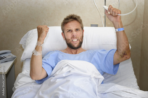 angry patient at hospital room in bed pressing nurse call button upset