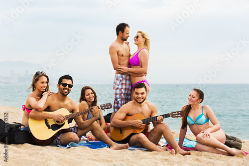 Adults with guitar at beach © JackF