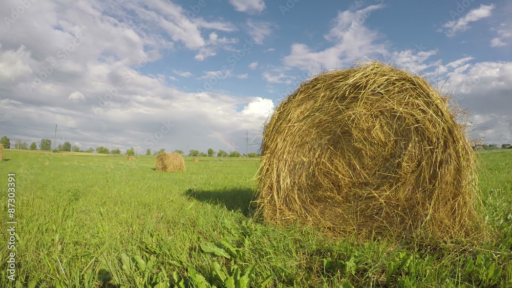 landscape with hay bales on summer agriculture field and rainbow. Timelapse 4K landscape with hay bales on summer agriculture field and rainbow. Timelapse 4K