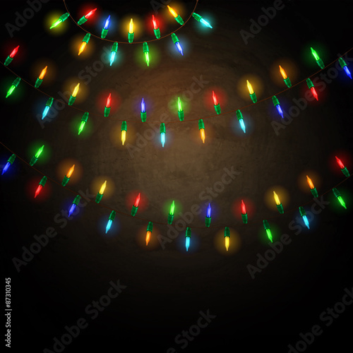 Colorful glowing christmas lights on blackboard background