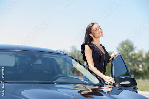 Beautiful young woman is opening the door of her transport