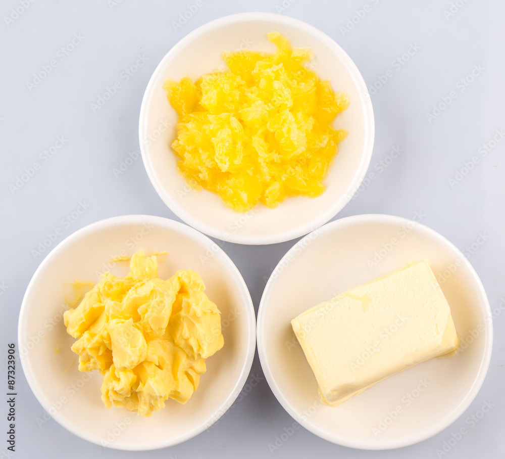 A block of butter, margarine and ghee in white bowls A block of butter, margarine and ghee in white bowls