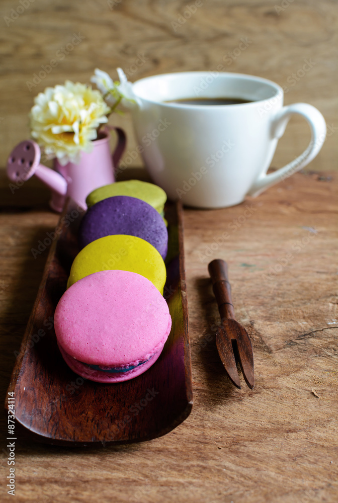 Colorful macaroons and a cup of coffee on wooden table Colorful macaroons and a cup of coffee on wooden table