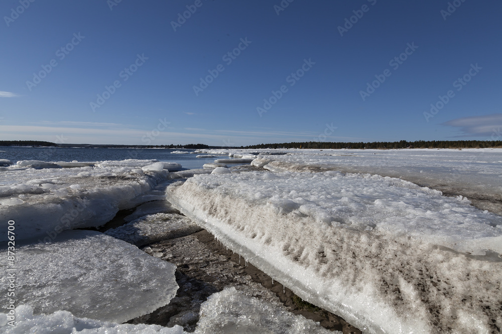 A set of chuncks of ice during the spring on a beach. 