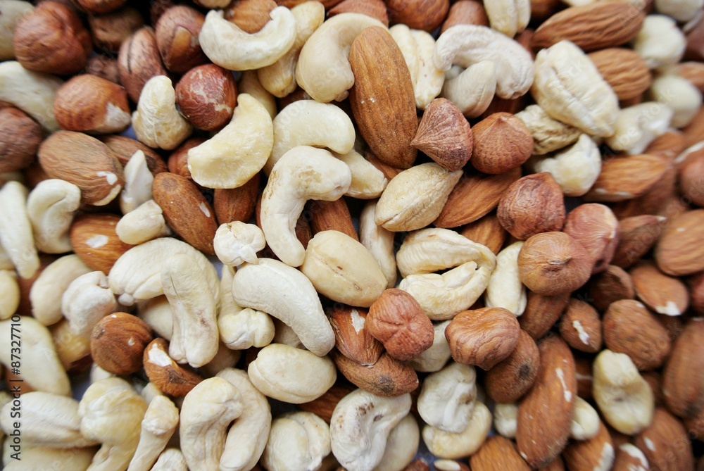 Close-up of a pile of various nuts - almonds, cashews and hazelnuts. Concept of clean/healthy eating; organic, unprocessed food; paleo diet.